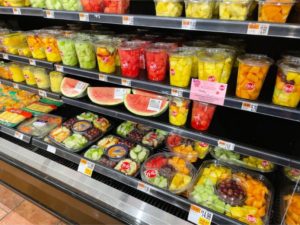 fruit in plastic food packaging on display in a grocery store