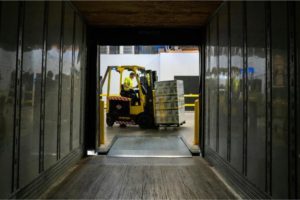 A forklift carrying boxes in a warehouse