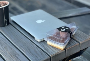 A computer and a cup of coffee on a bench